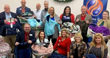 Okaloosa Gas donates 300 coats for children in need okaloosa gas employees pose with coats