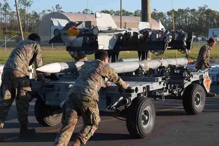 U.S. Airmen with the 325th Munitions Squadron push a munitions handling trailer at Tyndall Air Force Base, Florida