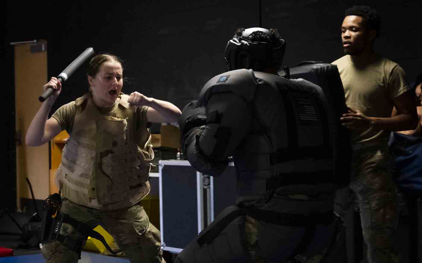 A female Airman attacks a simulated attacker during a baton training session.