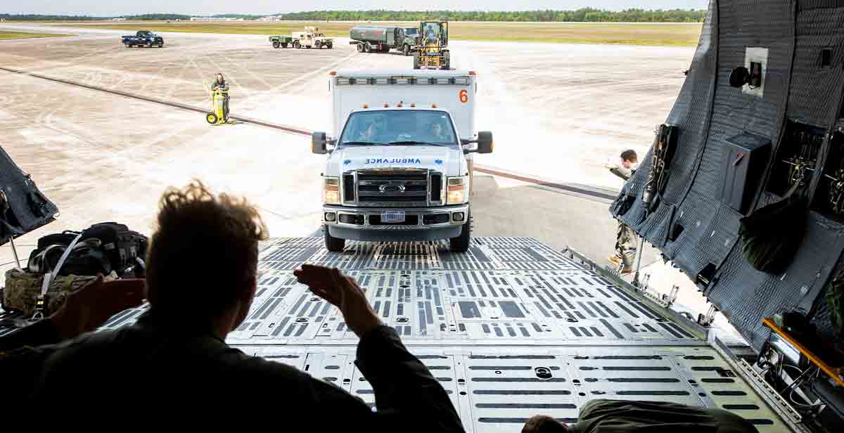 loadmaster guides ambulance up ramp into a C-5 Super galaxy aircraft