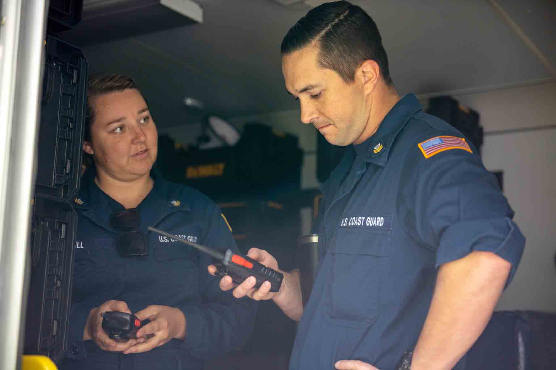 Two Coast Guard members assigned to the Gulf, Atlantic, and Pacific Strike teams test hand-held radios.