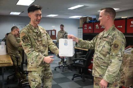 U.S. Air Force Tech Sgt. Kenneth Sutton, the 901st Special Operations Aircraft Maintenance Squadron assistant first sergeant, hands a cookie bag to Airman Sean Kim, a 901st SOAMXS electronic warfare technician, at Hurlburt Field