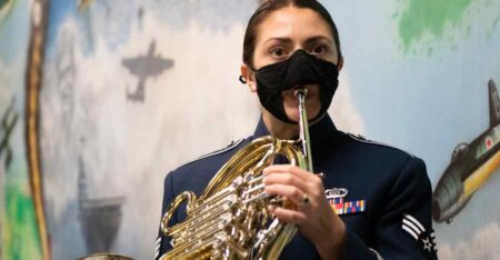 Senior Airman Rose Valby, a Freedom Brass member, warms up on her French horn