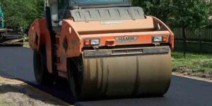 Road roller paving fresh asphalt.