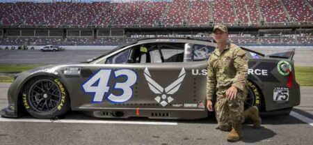 Tech. Sgt. Andrew Brockman, 96th Maintenance Group, stands next to the Air Force-sponsored NASCAR car at Talladega Superspeedway