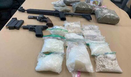 Weapons and drugs were reportedly located during a search warrant