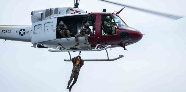 A Survival, Evasion, Resistance and Escape student from the 492nd Special Operations Wing reaches the 413th Flight Test Squadron's UH-1 Huey