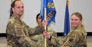 U.S. Air Force Col. Adam Shelton, 505th Test and Training Group commander gives the 605th Test and Evaluation Squadron guidon to Lt. Col. Leslie Woll,