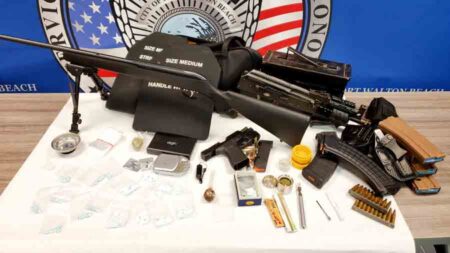 weapons and drugs seized in a search on a tabletop with Fort Walton Beach Police Department seal in background