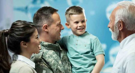 husband, wife and child smiling with doctor at military medical clinic