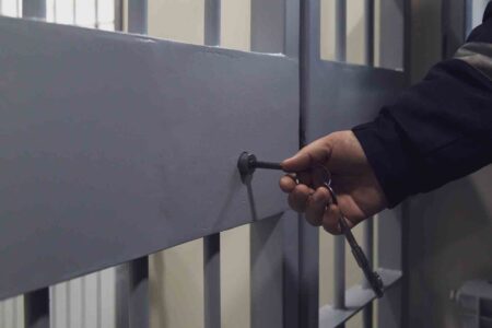 prison cell, hand turning key in lock