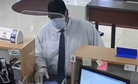 Robbery suspect at teller window at McCoy Federal Credit Union in Belle Isle, Florida