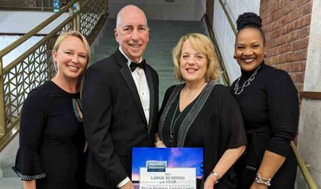 Four Eglin Federal Credit Union officials in a group on a staircase with the 2022 Large Business of the Year Award.