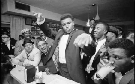 Muhammad Ali—then still called Cassius Clay— celebrating in the crowded coffee shop of the Hampton House Motel in 1964.