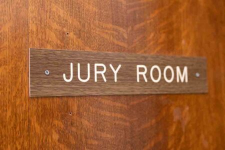 "Jury Room" sign on the wooden door of the courthouse.