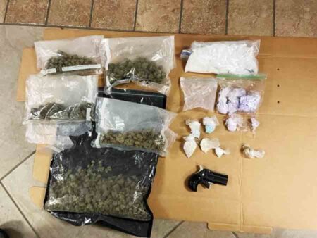 baggies of narcotics, marijuana, firearm displayed on table