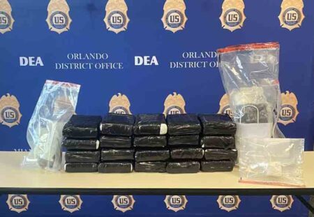 20 one-kilo packages of Cocaine wrapped in black plastic displayed on a table