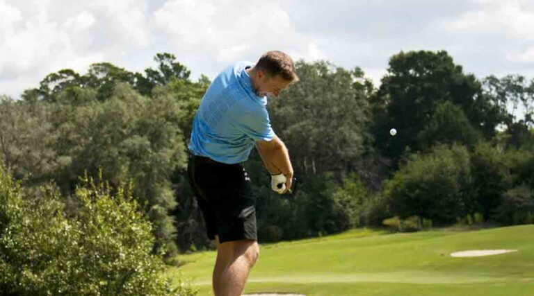 Golfer teeing off, ball in the air, at Eglin golf course.