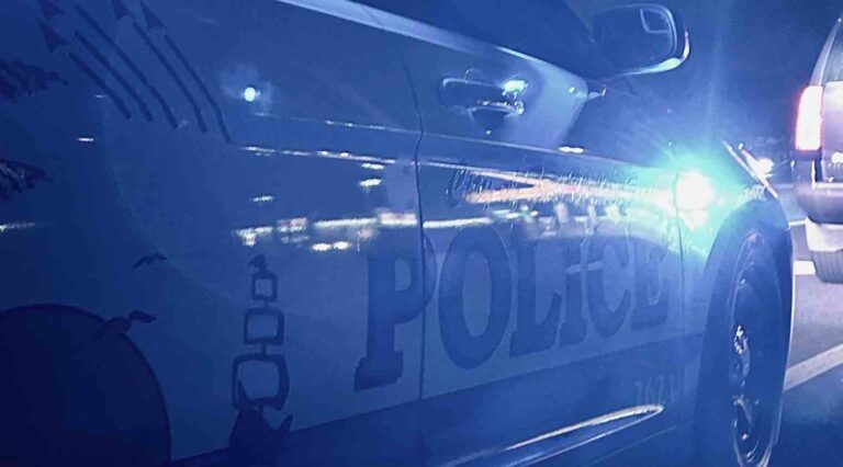 Passenger's side of Fort Walton Beach Police patrol vehicle at night reflecting blue lights.
