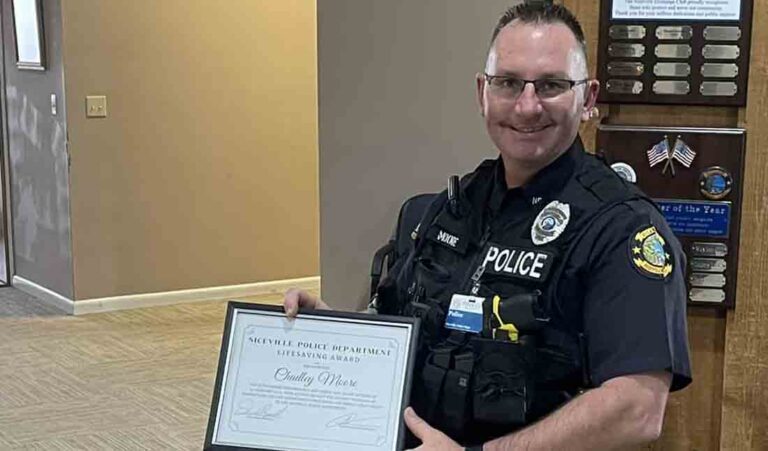 Chadley Moore standing in the lobby of the Niceville Police Department holding his lifesaving award.