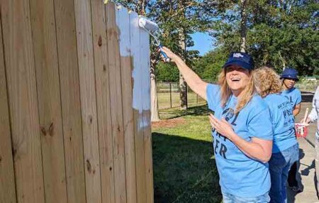 Eglin Federal Credit Union employees paint a fence