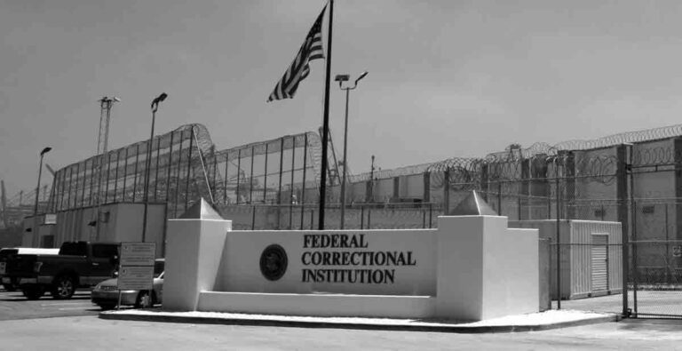 Federal Correctional Institution prison. fence and razor wire. black and white image