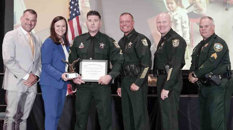 Master Deputy Donald Roenbeck displays award posing with five dignitaries