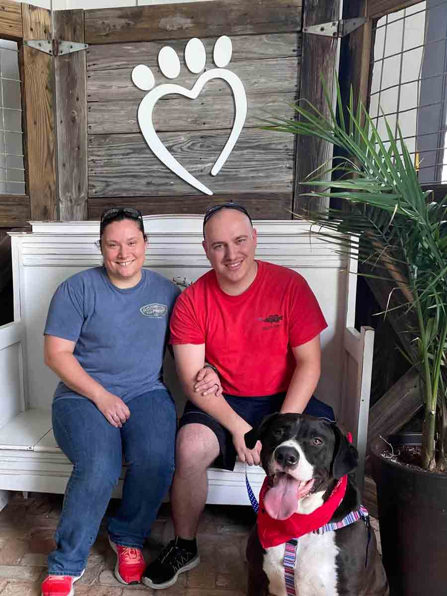 Gunner the dog with his new owners, a married couple