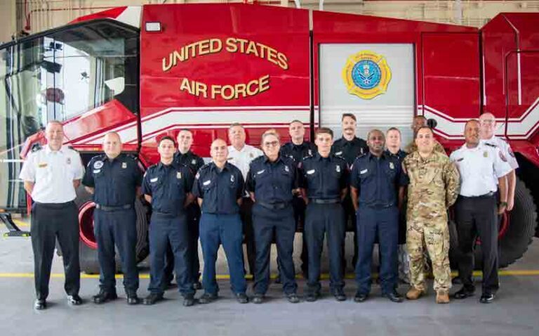 16 Eglin Fire and Emergency Services Airmen pose in front of a fire truck.