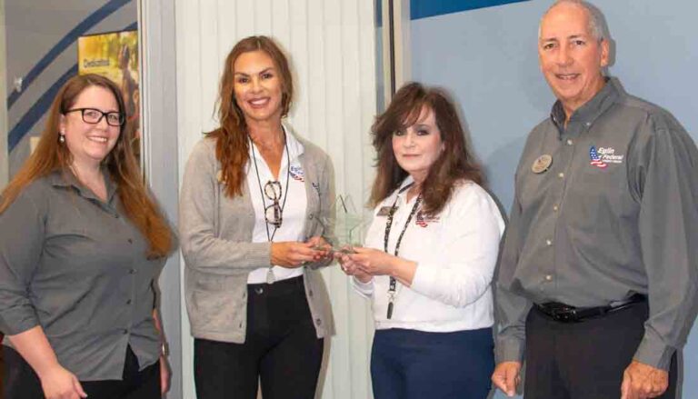 group of four people with award