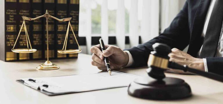 A male lawyer signing a document at desk