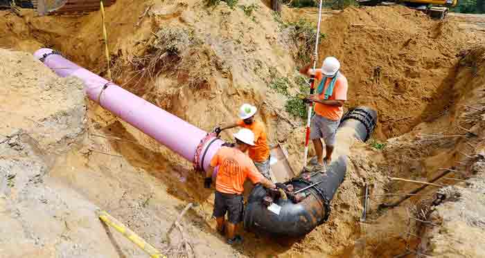 three men working on installing reclaimed water pipeline
