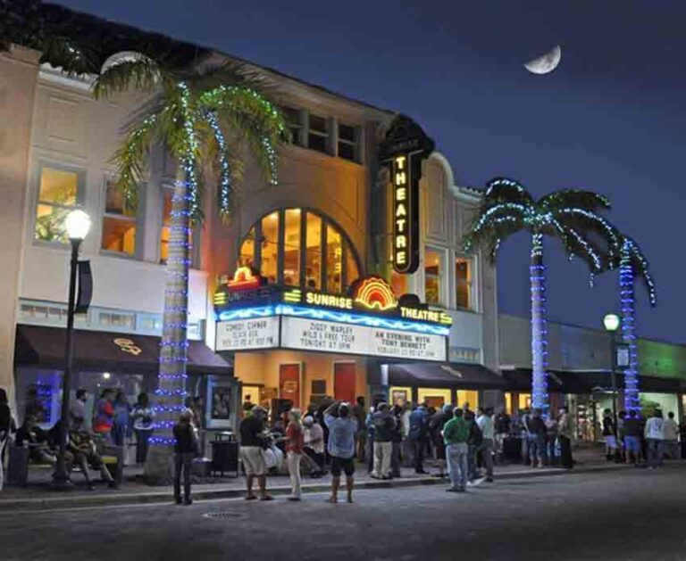 The Sunrise Theatre after dark with crowd of people outside