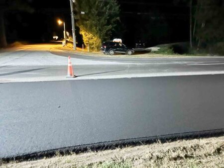 newly paved travel lane at night near lighted intersection