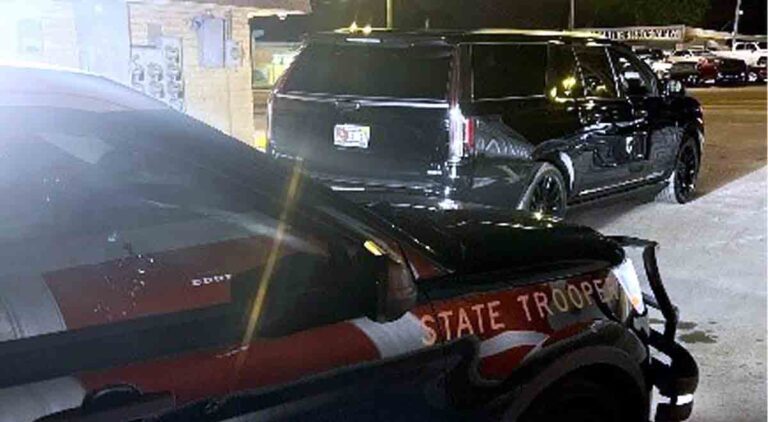 Florida Highway Patrol Vehicle and black Cadillac Escalade parked after dark