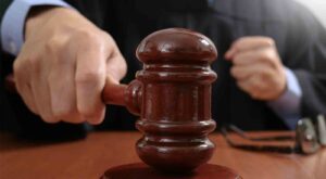 judge in a courtroom striking the gavel,