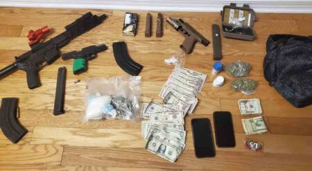 guns, drugs, cash spread out on a floor