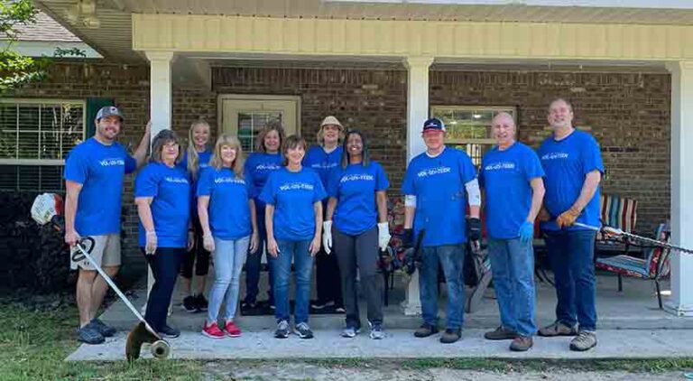 11 Eglin Federal Credit Union employees in a group at the entrance of Children in Crisis in Fort Walton Beach, Florida.