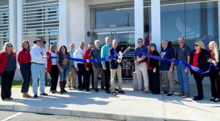 17 people in a line during the ribbon-cutting for the Eglin Federal Credit Union Pace Branch office.