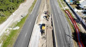aerial view of the U.S. 98 road widening project in Panama City Beach, Florida, showing heavy equipment in the median.