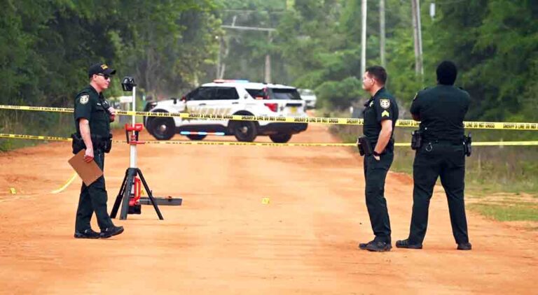 three deputies with the Walton County Sheriff's Office block a clay road while investigating a shooting in Mossy Head, Florida.