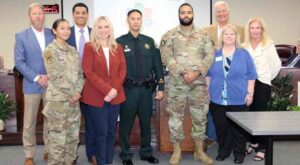 Okaloosa County Superintendent of Schools and School Board members standing in a group with first responders, military members who took part in a video project for the school district.