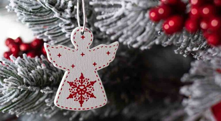 White Wooden Christmas angel on a Christmas tree. Macro photo.