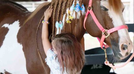 A young girl hugs a horse at the Exceptional Family Member Program horse event held at Sand and Spur Riding Club, Eglin Air Force Base, Fla.,