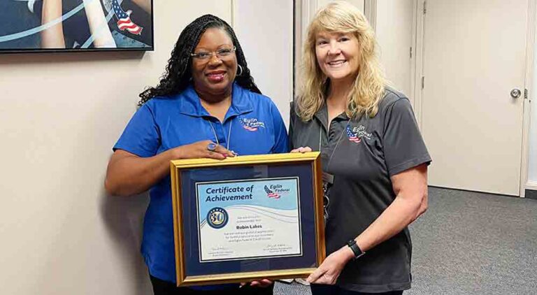 Eglin Federal Credit Union Human Resources Supervisor Robin Lakes holding framed certificate of achievement with SVP/Chief HR Officer Gina Denny