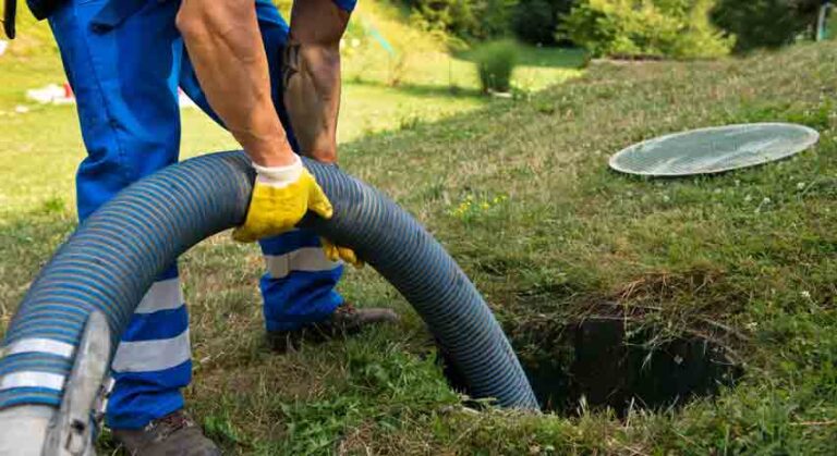 man pumping out household septic tank. Cleaning sludge from septic system.