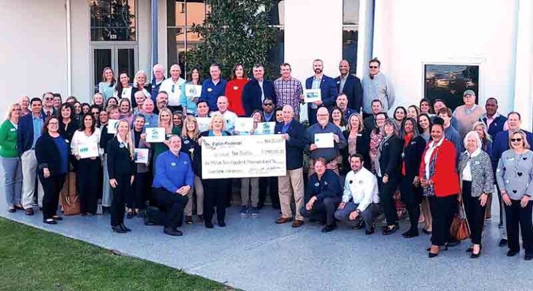 Eglin Federal Credit Union staff and nonprofit representatives posing with a ceremonial check for $1.9 million in community donations.