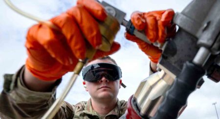 Close-up of Air Force Tech. Sgt. Collin Stratton as he attaches the single-point nozzle adapter to a fuel source at Eglin Air Force Base, demonstrating its ease of use and efficiency in collecting fuel samples.