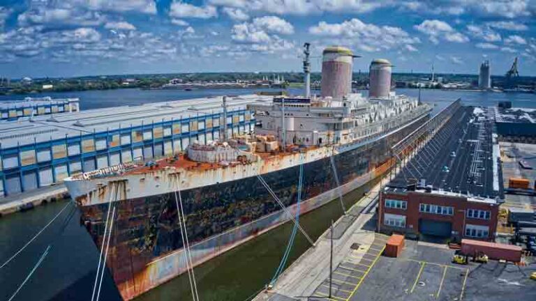 SS United States, with rust and faded painted, tied to a dock