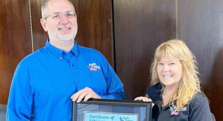 Eglin Federal Credit Union SVP/Chief HR Officer Gina Denny presents a Certificate of Achievement to SVP/Chief Technology Officer Tim Farnsworth, recognizing his 30 years of service. Both are smiling in a professional setting.